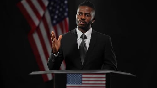 Man Giving Speech at Podium With American Flag