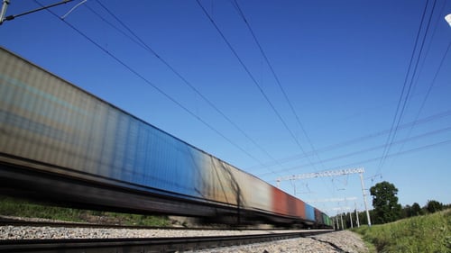Freight Train on Railroad Tracks Rushes by Fast