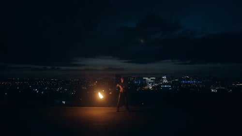 Performer Manipulating Flaming Torches at Night