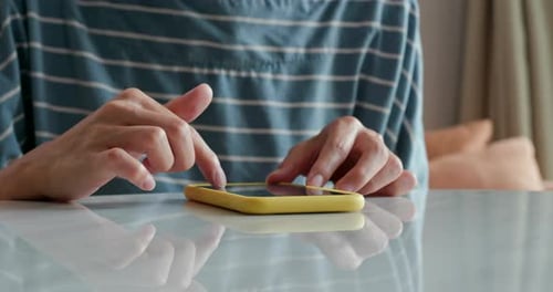 Hands Using Mobile Phone on Table