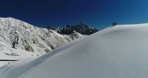 Mountain Aerial Fly By Hiking People Pointing Across Snowy Landscape