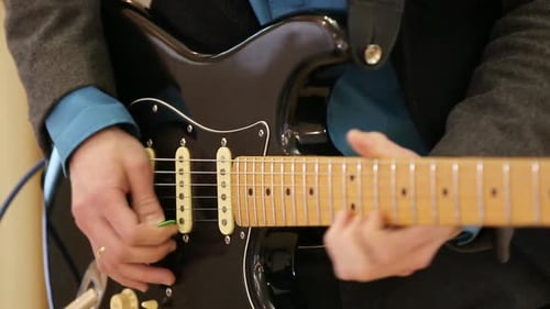 Close-up of Male Hands Playing Acoustic Guitar. A Guitarist Plays Classical Guitar on Stage in a