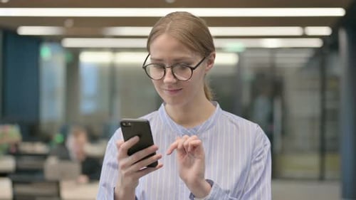 Woman Using Mobile Phone in an Office Setting
