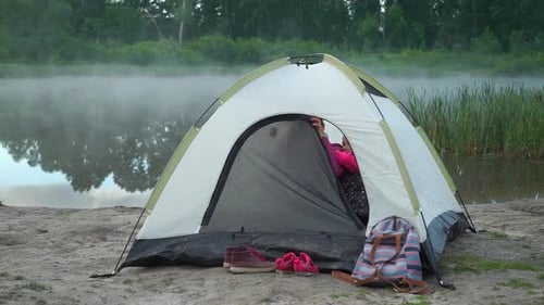 Young Woman with Daughter in a Tent Near the Lake