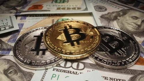 Bitcoin crypto gold and silver coins on 100 dollar bills in close up view