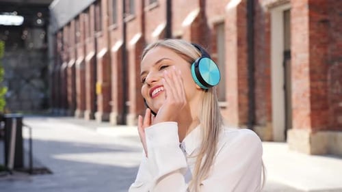 Smiling Young Lady Listening to Music Standing Outdoors Good Sound Quality