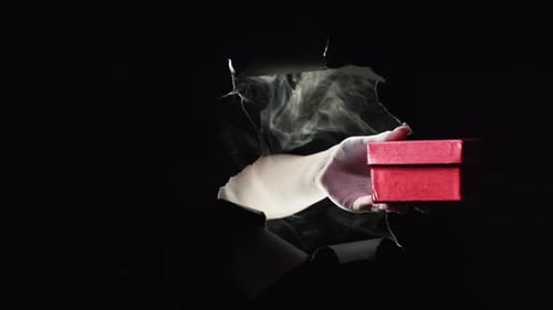 Hand Gives Red Gift Box Through Hole