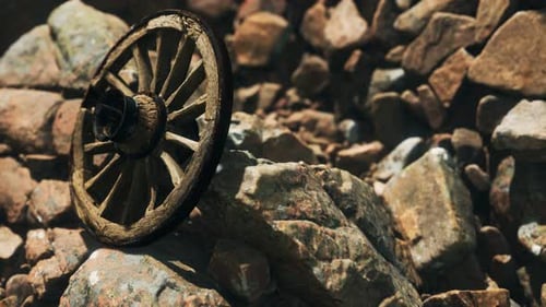 Abandoned Wooden Wagon Wheel on Rocky Terrain