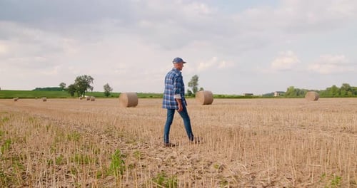 Farmer Using Digital Tablet While Examining Field