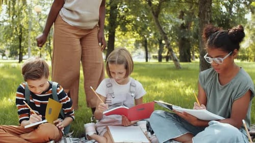 Diverse Schoolkids Having Lesson Outdoors in the Park