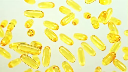 Golden Capsules Floating on White Background