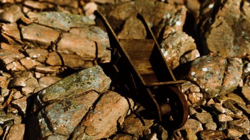 Abandoned Wooden Mine Wheelbarrow on Rocks