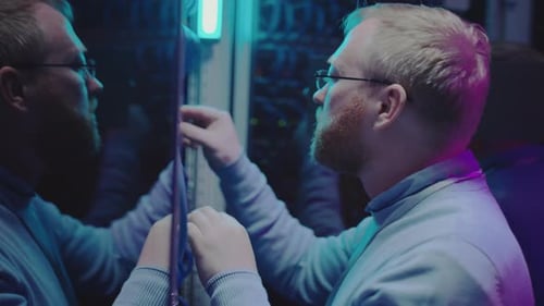Technician Inspecting Server Cables in Data Center