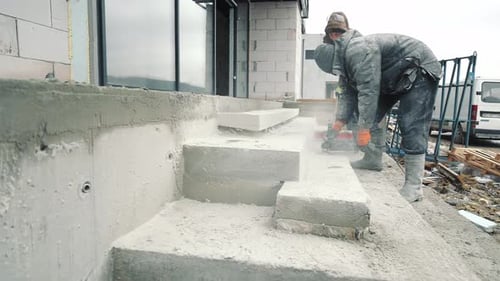 Ein Bauingenieur, der die Oberfläche einer Betontreppe mit Hilfe von Werkzeugen schleift
