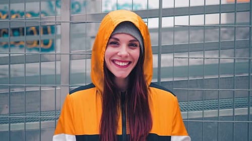 Smiling Woman in Yellow Jacket in Urban Setting