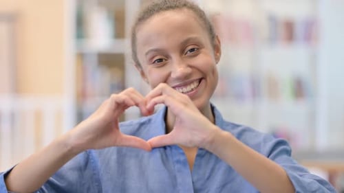Smiling Woman Makes Heart Shape with Hands