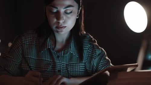 Woman Working Late at Night on Tablet