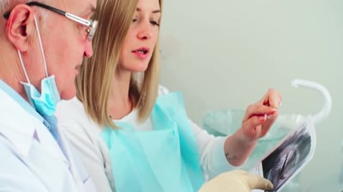 Zahnarzt und Patient sprechen über zahnärztliche Röntgenaufnahmen