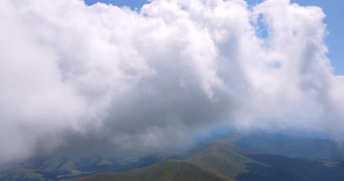 Aerial View of Verdant Mountains Partially Veiled by Clouds