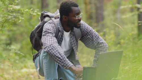Ecologista trabalhando em laptop na floresta