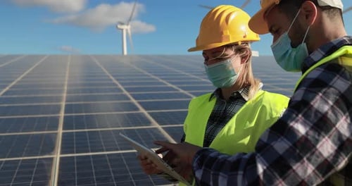 Working people with digital tablet wearing safety masks- Alternative renewable energy