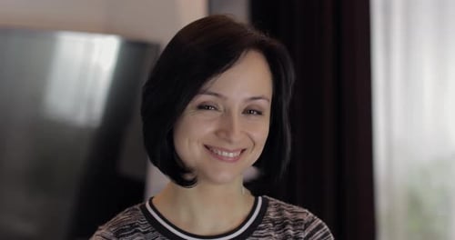 Woman with short dark hair smiles at camera