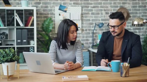 Business Partners Talking About Work Then Doing High-five and Laughing in Office