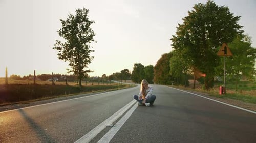 Jeune femme prenant un selfie sur la route. Belle jeune femme souriante et posant pour un selfie assise
