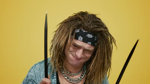 Emotional Musician Playing Drums in Studio. Man Holding Drum Sticks Indoors