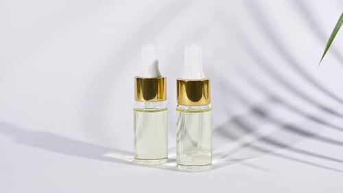 Serum Bottles with Gold Accents and Palm Leaf Shadows