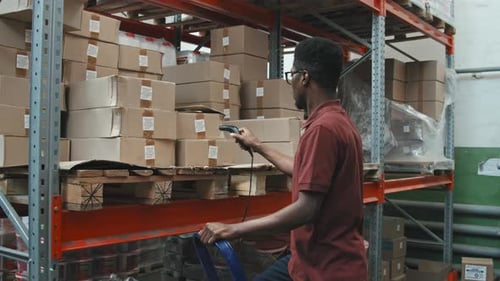 Trabalhador masculino verificando caixas com leitor de código de barras