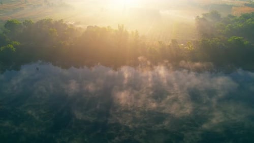 4K : Aerial view, flying over a rural reservoir, morning mist. beautiful sunrise