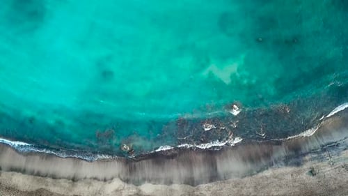 Blick von oben auf einen einsamen schwarzen Vulkanstrand