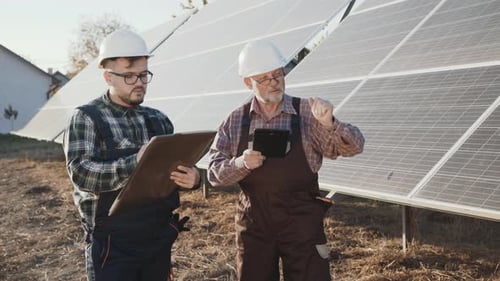 Zwei Ingenieure analysieren die Arbeit alternativer Solarbatterien in einer Fabrik