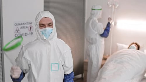 Healthcare Workers in Protective Gear Caring for Patient