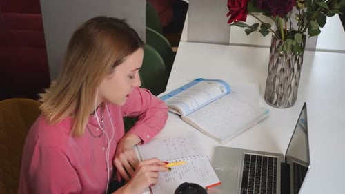 Woman Studies Notebook with Laptop and Books