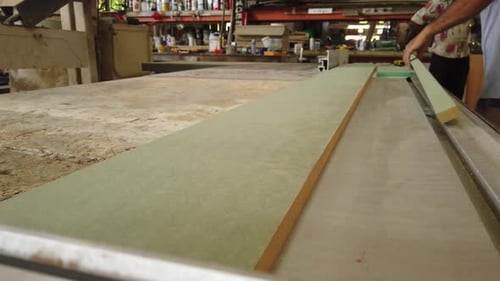 Man Crafts Wood in a Busy Workshop