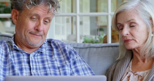 Senior Couple Relaxing at Home Using Laptop