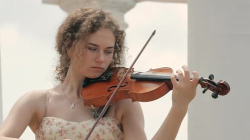 Woman Skillfully Playing Violin by Classical Columns