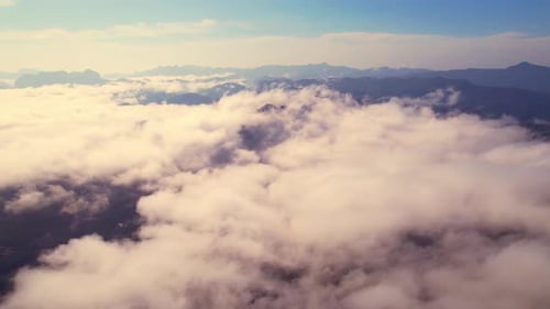 Drone flying above the clouds during sunrise