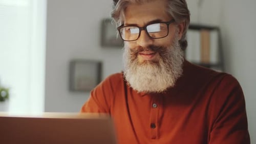 Bearded Businessman Working on Laptop at Office Desk