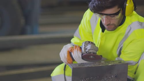 Man Grinding Metal with Sparks in Industrial Setting