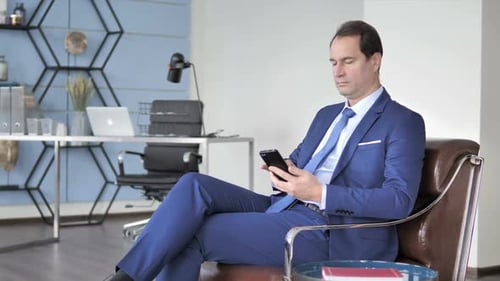 Businessman Using Smartphone in Modern Office Setting