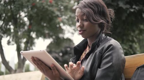 Young Woman Using Tablet in Urban Park Setting
