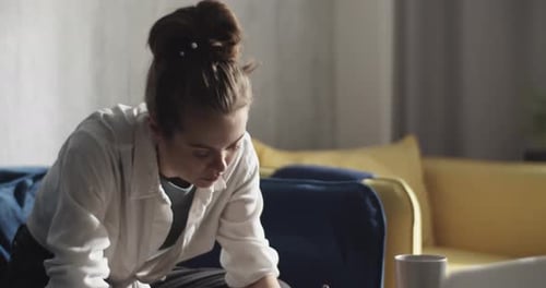 Young Adult Writing at Home with Laptop