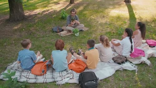 Man Teaching Children about Plants in Park