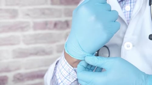Man Doctor Wears Medical Gloves Close Up