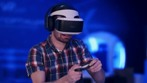 геймер в VR очках с удивленным и счастливым лицом