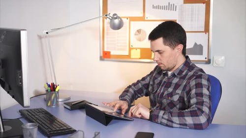 Office Worker Manager Sitting at His Work Place, Using a Laptop.