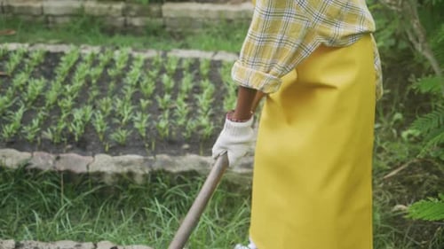 Closeup children boy using shovel dig soil for plants in the garden.